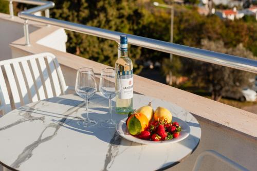 a plate of fruit and a bottle of wine on a table at Kalkan Suites Hotel in Kalkan