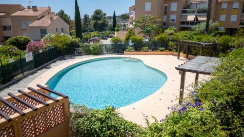 a swimming pool in a yard with a table and chairs at Le Corsaire - Séjour Relaxant, Plage & Piscine in Carqueiranne