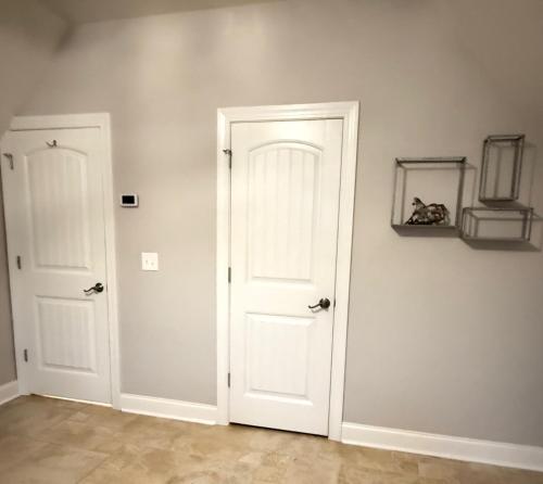 an empty room with two white doors at Hidden Stables on Chancey Pond Rentals, LLC in Aiken