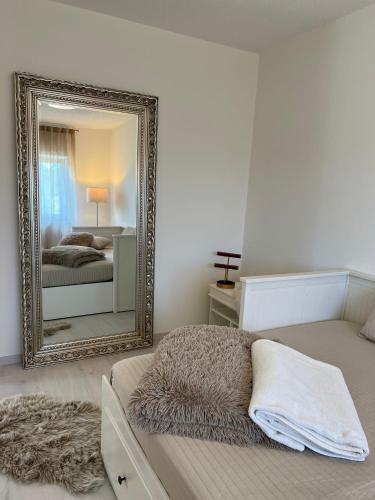 a bedroom with a mirror and a bed with a blanket at Ferienwohnung Hügel Blick in Brücken