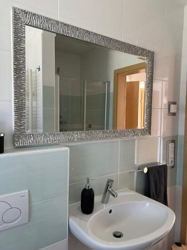 a bathroom with a sink and a mirror at Ferienwohnung Hügel Blick in Brücken