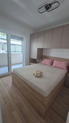 a bedroom with a large white bed with pink pillows at Apartman Ella in Split