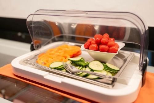 a plastic container with vegetables and crackers in a refrigerator at Gästezimmer Steiner in Gamlitz