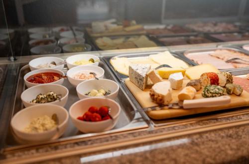 a display case with different types of cheese and other foods at Gästezimmer Steiner in Gamlitz