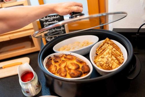 a pan with three bowls of food on a counter at Gästezimmer Steiner in Gamlitz