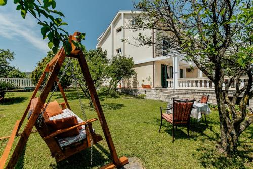 a swing in a yard in front of a house at Bella Apartments in Sušići