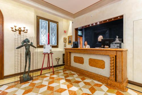 a room with a statue of a man behind a counter at Art Hotel Commercianti in Bologna