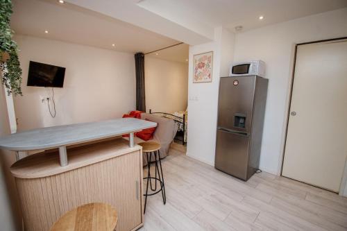 a small kitchen with a table and a refrigerator at Ecrin Pontissalien - Studio with Parking in Pontarlier