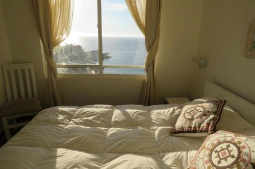 a bedroom with a bed and a window with the ocean at Vista y Mar in Valparaíso