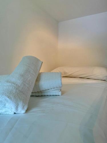 a white bed with a pillow on top of it at Summer Escape - Exclusive Chalet with private garden in Prada