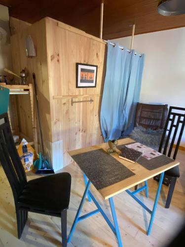 - une table et deux chaises dans une pièce avec porte dans l'établissement ChéMémé!, 