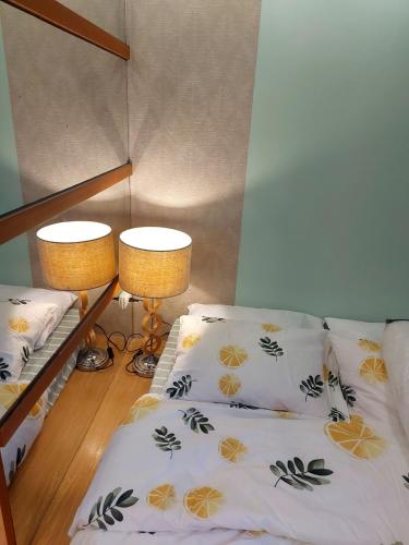 a bedroom with two bunk beds and two lamps at Great Location, Swimming pool, Shops, Staycation in Iloilo City