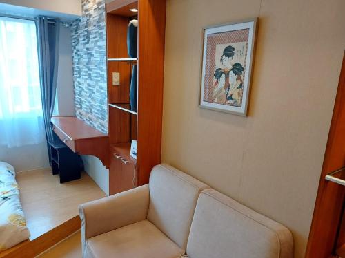 a living room with a couch and a desk at Great Location, Swimming pool, Shops, Staycation in Iloilo City