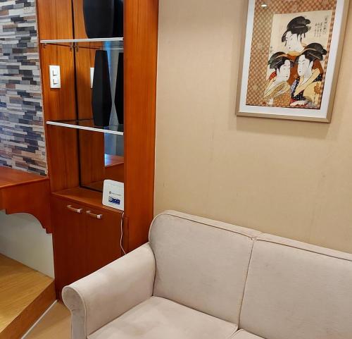 a living room with a couch and a cabinet at Great Location, Swimming pool, Shops, Staycation in Iloilo City