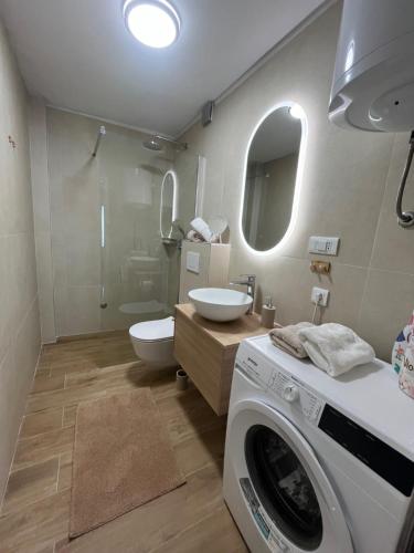 a bathroom with a washing machine and a toilet at Apartments Bepo in Komiža