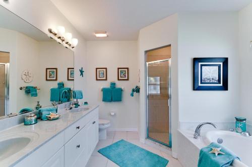 a bathroom with two sinks and a tub and a toilet at Beach Bliss in Bradenton