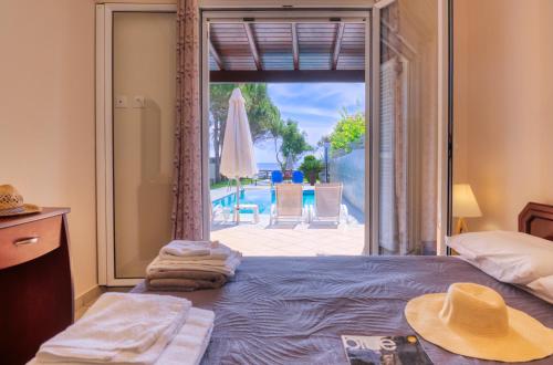 a bedroom with a bed with a view of a pool at Villa Angela in Ágios Matthaíos