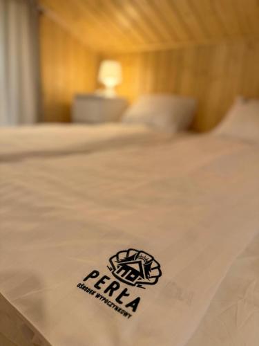 a bed with a pkr logo on top of it at Perła in Stegna