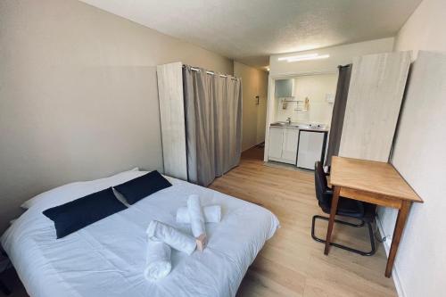 une chambre avec un lit avec des oreillers blancs dessus dans l'établissement Studio of 21m 2 near the heart of Toulouse, à Toulouse