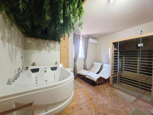 a large bathroom with a tub and a bedroom at VILLA REGINA - Suite con Spa Sperlonga Vertice Rooms in Fondi