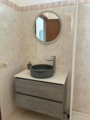 un bagno con lavandino e specchio di Casa vacanza Foceverde lido a Lido di Latina