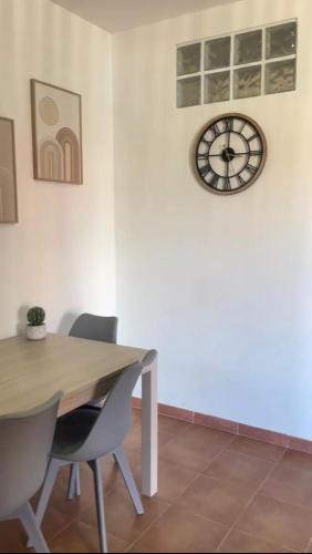 a dining room with a table and a clock on the wall at Casa vacanza Foceverde lido in Lido di Latina