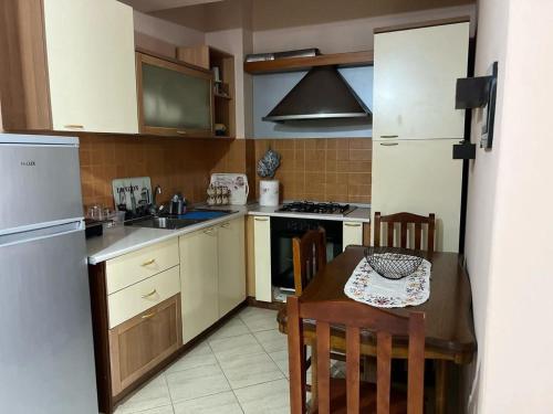 Simple Apartment في أوريكوم: مطبخ صغير به طاولة وثلاجة