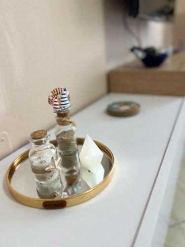 Simple Apartment في أوريكوم: زجاجة زجاجية صغيرة على صينية على المنضدة