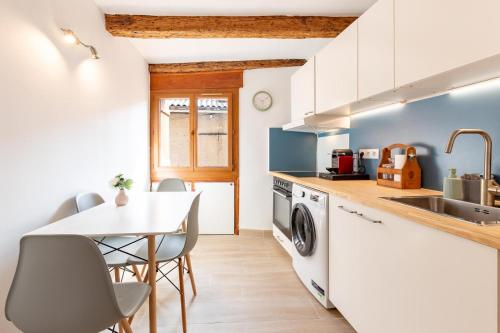 a kitchen with a table and a sink and a washing machine at La maison d'Acoya in Valdeblore