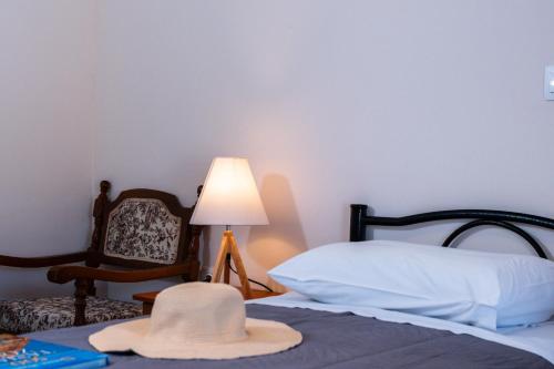 a hat sitting on top of a bed with a chair at Villa Angela in Ágios Matthaíos
