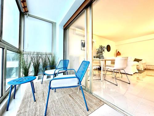 a living room with blue chairs and a table at Stylish Comfort in Mandelieu in Mandelieu-la-Napoule
