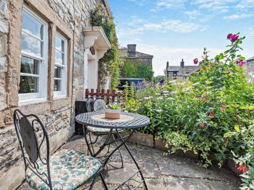 a patio with a table and chairs and flowers at 1 Bed in Ashford in the Water PK249 in Great Longstone