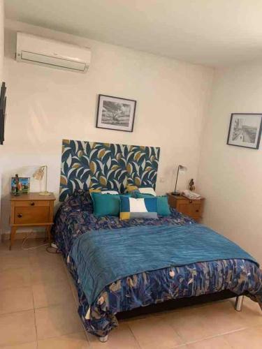 une chambre avec un grand lit avec une couverture bleue dans l'établissement Canet-en-Roussillon beach relaxation house, à Canet