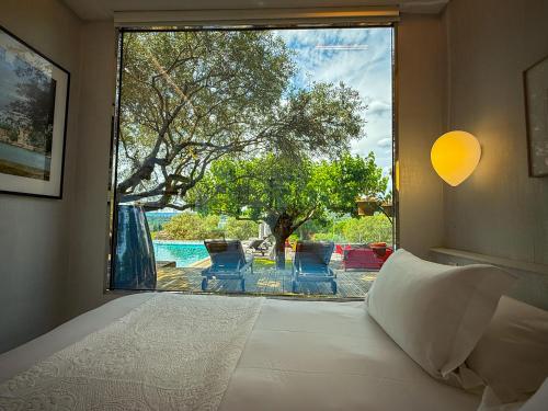- une chambre dotée d'une grande fenêtre offrant une vue sur la piscine dans l'établissement Le Poolhouse, Lodge avec piscine au coeur du Luberon, à Saint-Saturnin-lès-Apt