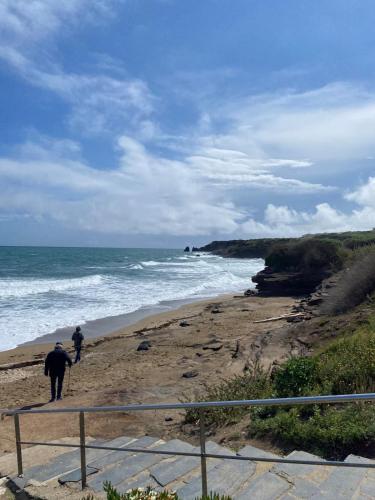 2 personnes marchant sur une plage près de l'océan dans l'établissement Appartement 4 personnes secteur falaise avec parking, au Cap d'Agde