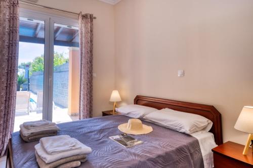 a bedroom with a bed with a hat on it at Villa Angela in Ágios Matthaíos