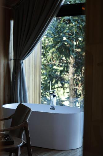 a bath tub in a room with a window at Refúgio de Altitude in Urupema