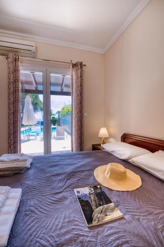 a room with a bed with a hat on it at Villa Angela in Ágios Matthaíos
