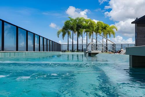 Una piscina con palmeras en un edificio. en Edf Time 1503 | Piscina | Academia | Jacuzzi, en Maceió