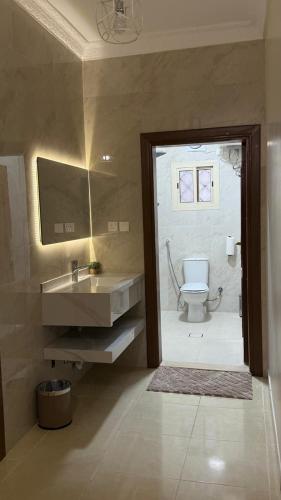 a bathroom with a toilet and a sink and a mirror at HomeStay in Jeddah