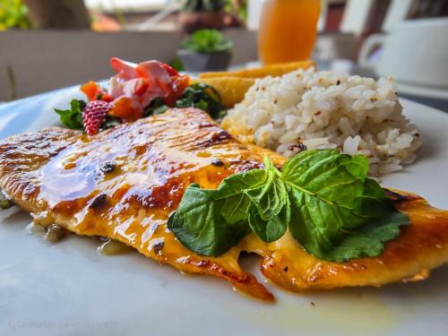 a plate of food with chicken and rice and greens at El Gran Boga in Villeta