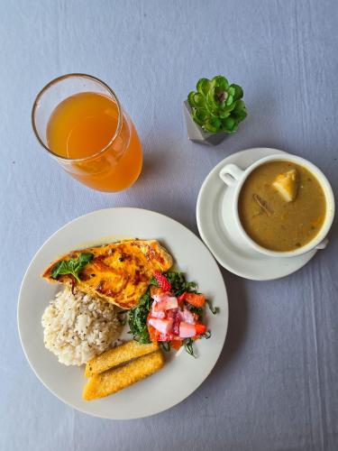 a plate of food with rice and a bowl of soup at El Gran Boga in Villeta