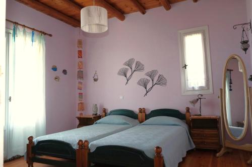 a bedroom with two beds and a mirror at Vereniki Andros guesthouse in Batsi