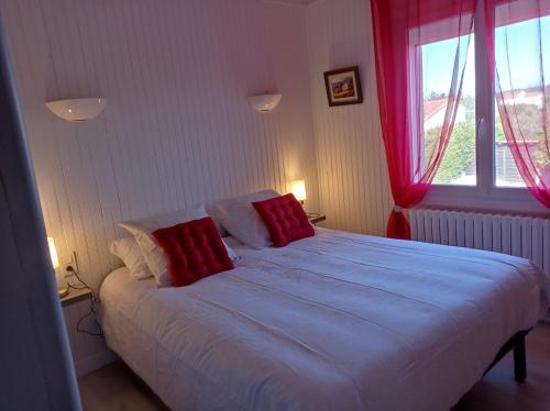 une chambre avec un lit avec des oreillers rouges et blancs dans l'établissement Charmant appartement dans maison Familiale, à Beaucaire