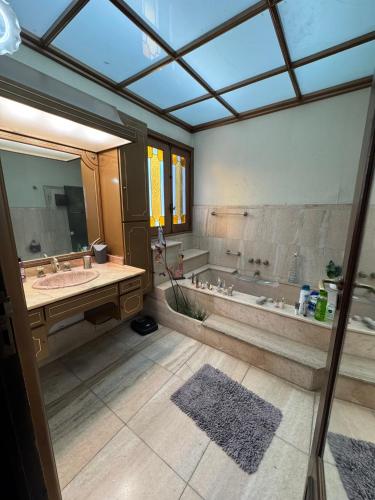 a bathroom with a tub and a sink and a mirror at Residencia Boutique in Mar del Plata