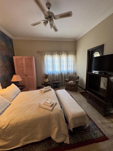 a bedroom with a large bed with a ceiling fan at Residencia Boutique in Mar del Plata