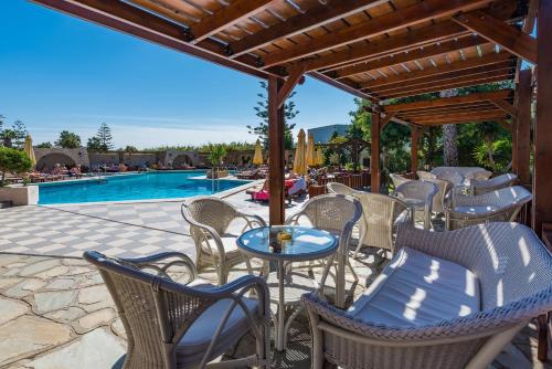 a group of chairs and tables next to a pool at Gaia Garden in Kos Town
