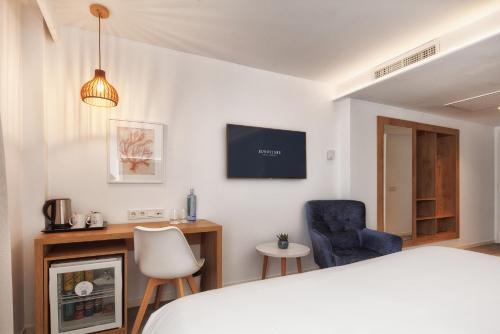 a bedroom with a bed and a tv on the wall at Eurostars Puerto de Ibiza in Ibiza Town