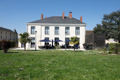 a large white house with a lawn in front of it at Auberge du Chateau Bleu in Tremblay En France