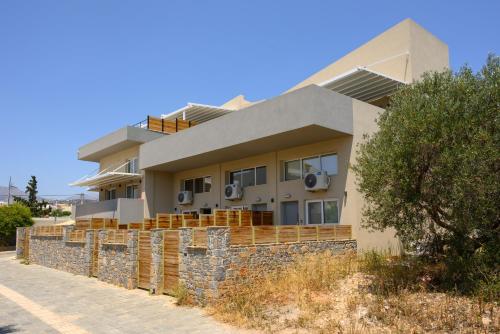 a house on a retaining wall with a stone fence at Cestrum Suites in Agios Nikolaos